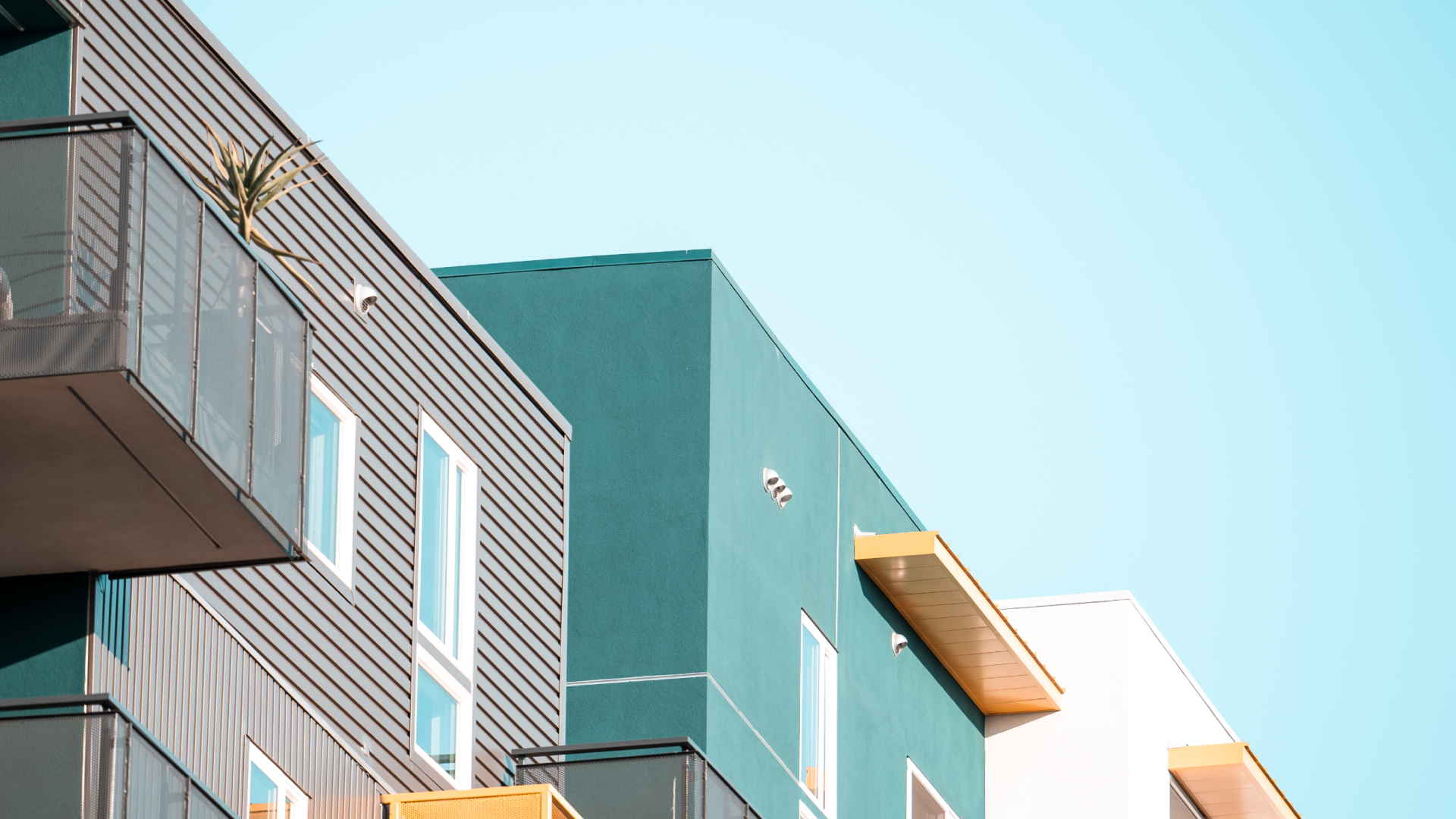 A cinematic photo of the tops of a colorful apartment building, with half of the photo taken up by the sky