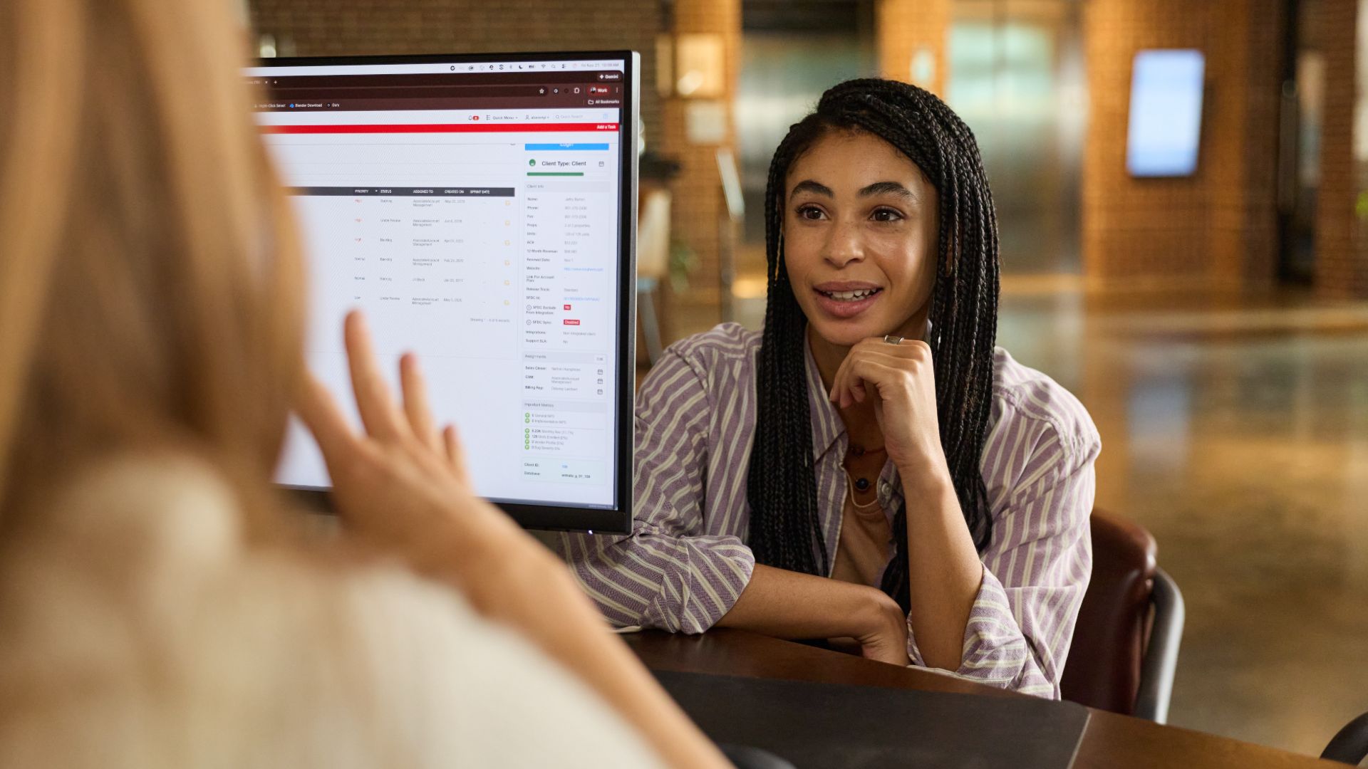 Leasing agent speaking with a prospective renter across a desk in a property management office.