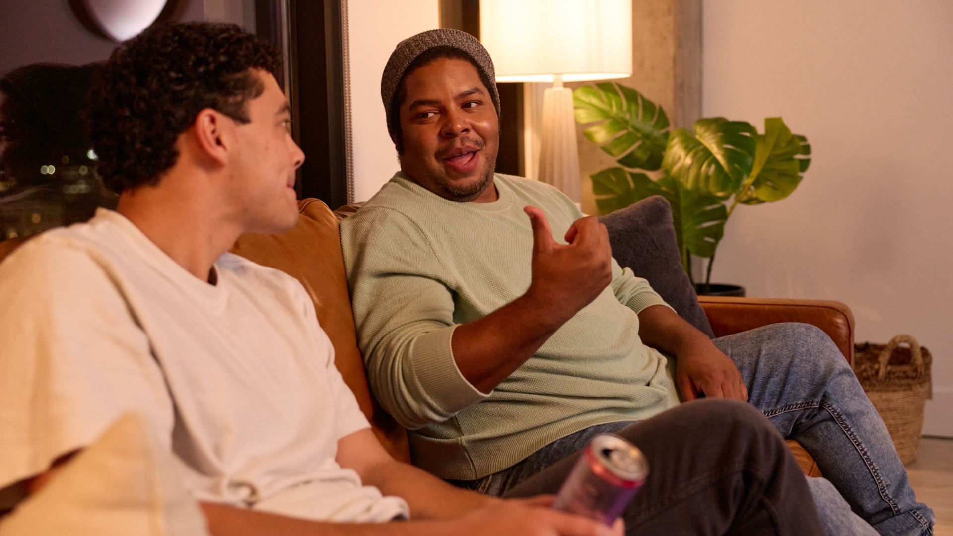 two people sitting on a couch talking to each other