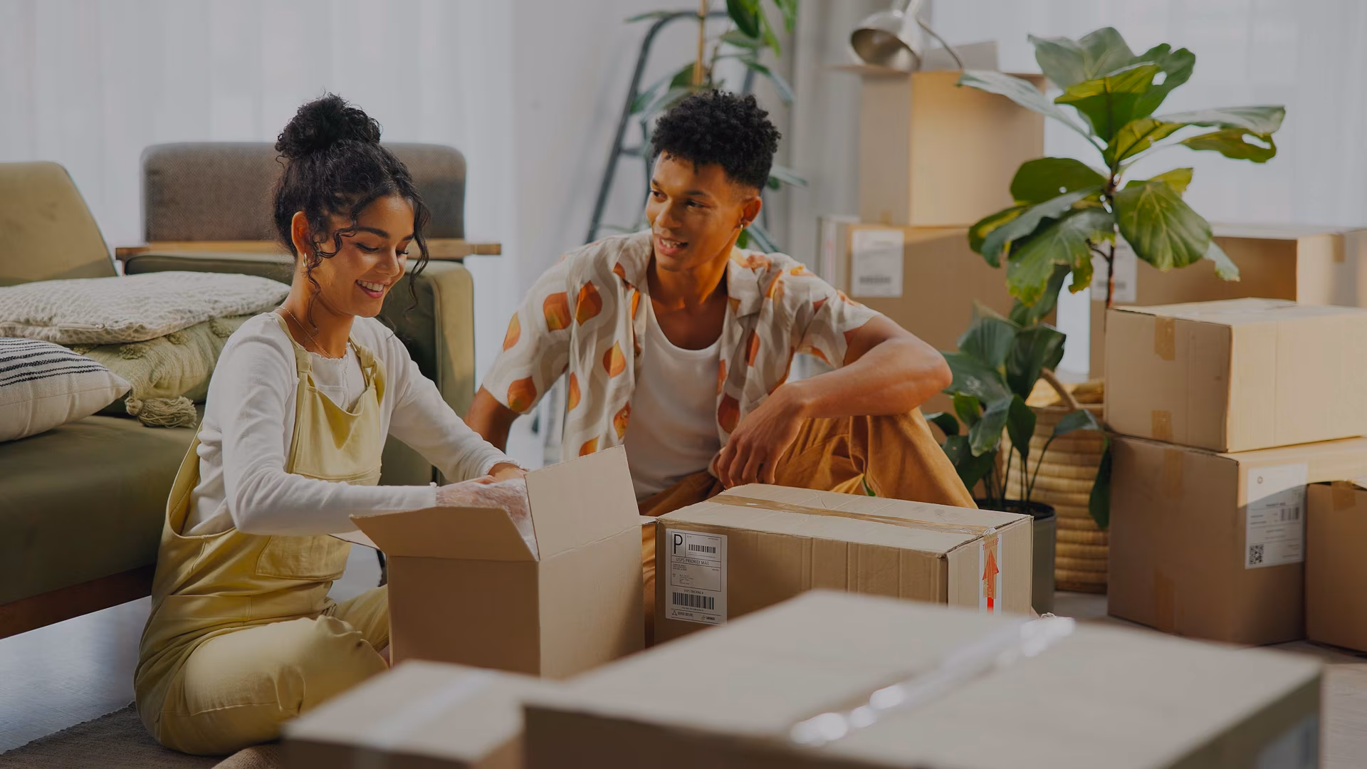 A man and woman sit on the floor in front of a couch having a discussion