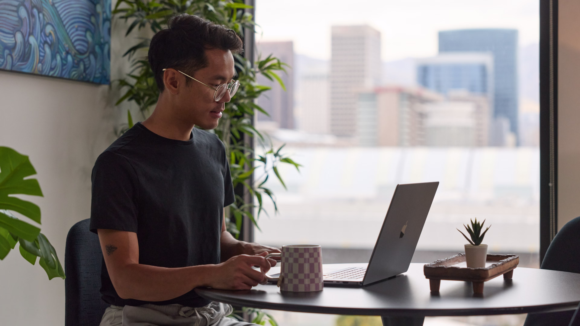 A person sitting at a desk on their laptop