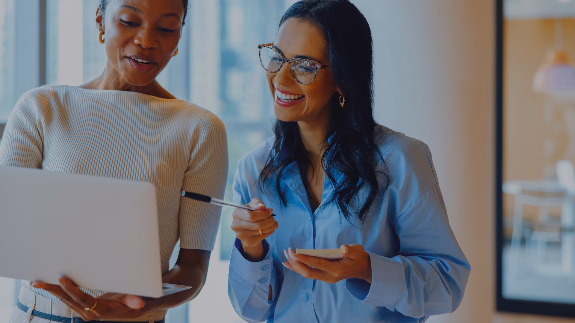 Two women standing and looking at a computer screen