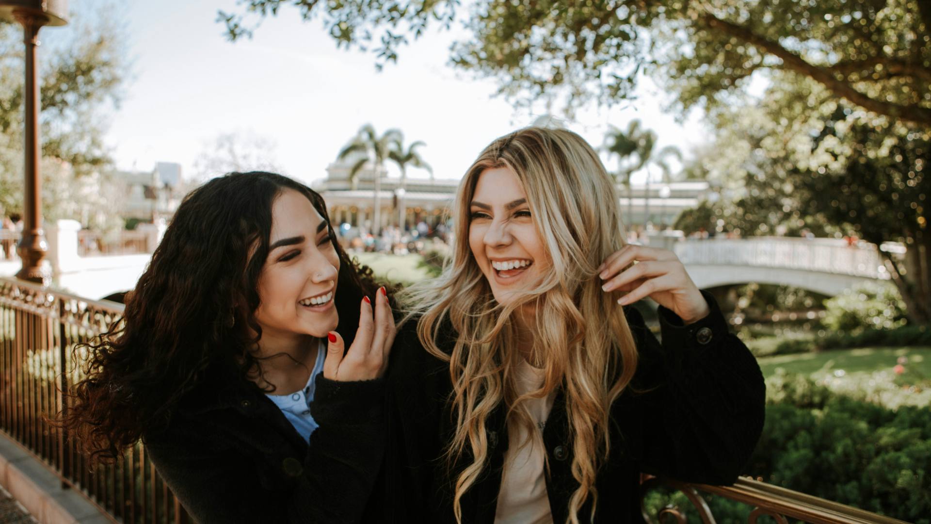 Two women smiling and talking outdoors, representing the trust and community that strengthen resident relationships.
