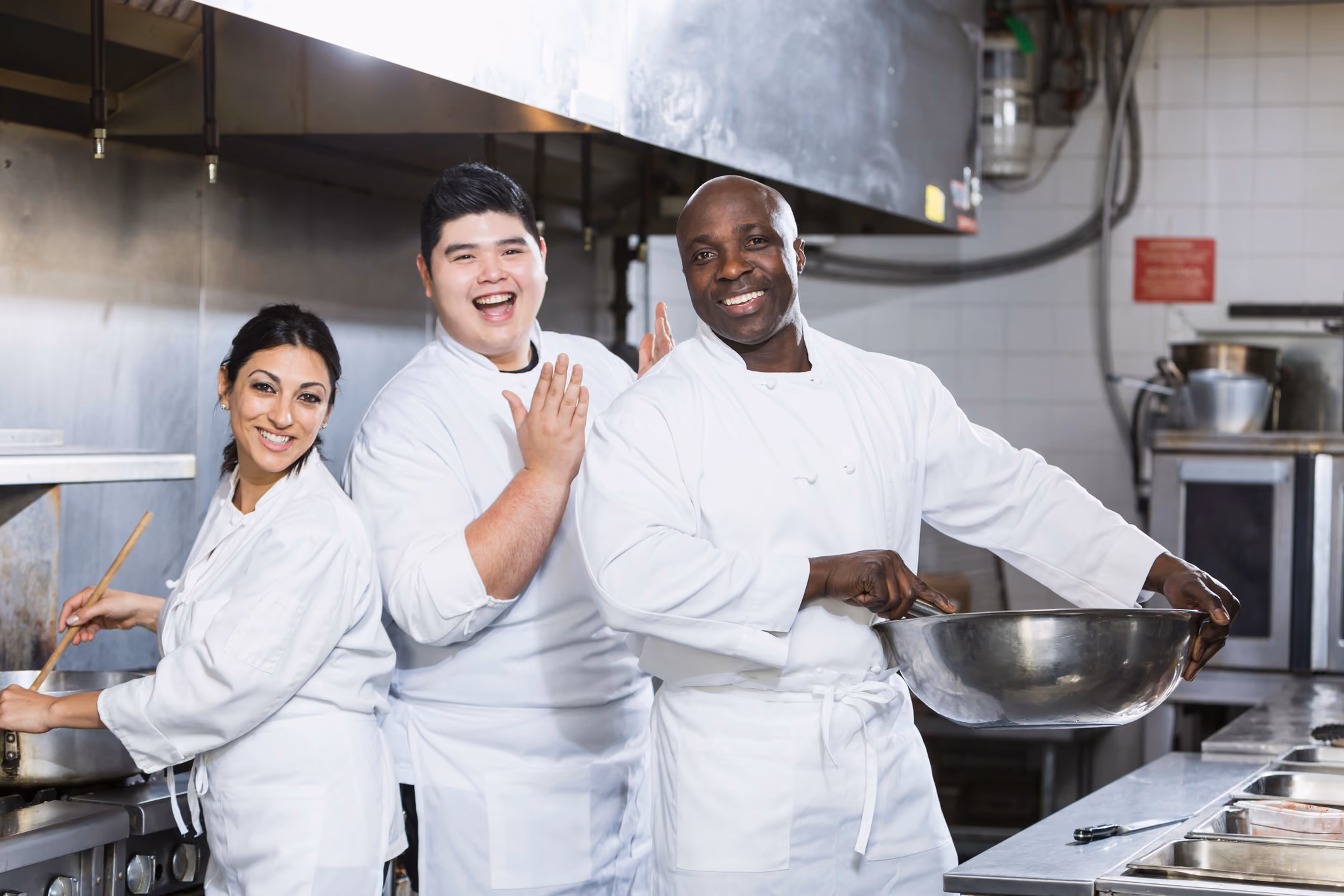 Three chefs working in a kitchen and preparing food