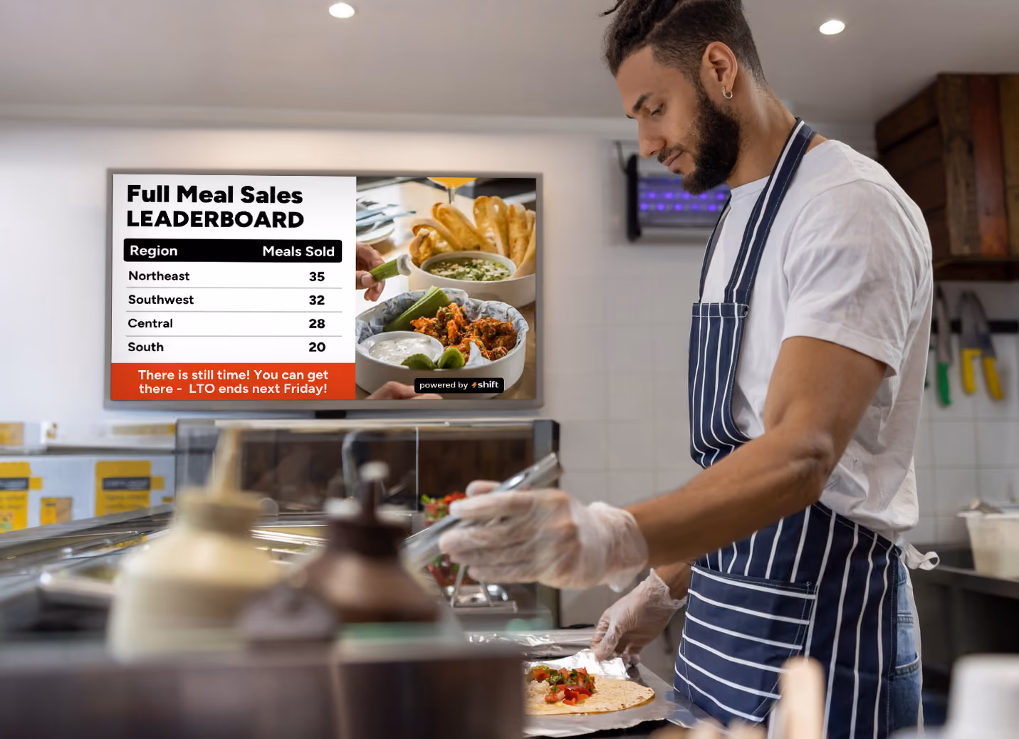 A chef preparing some food with a digital screen in the background 