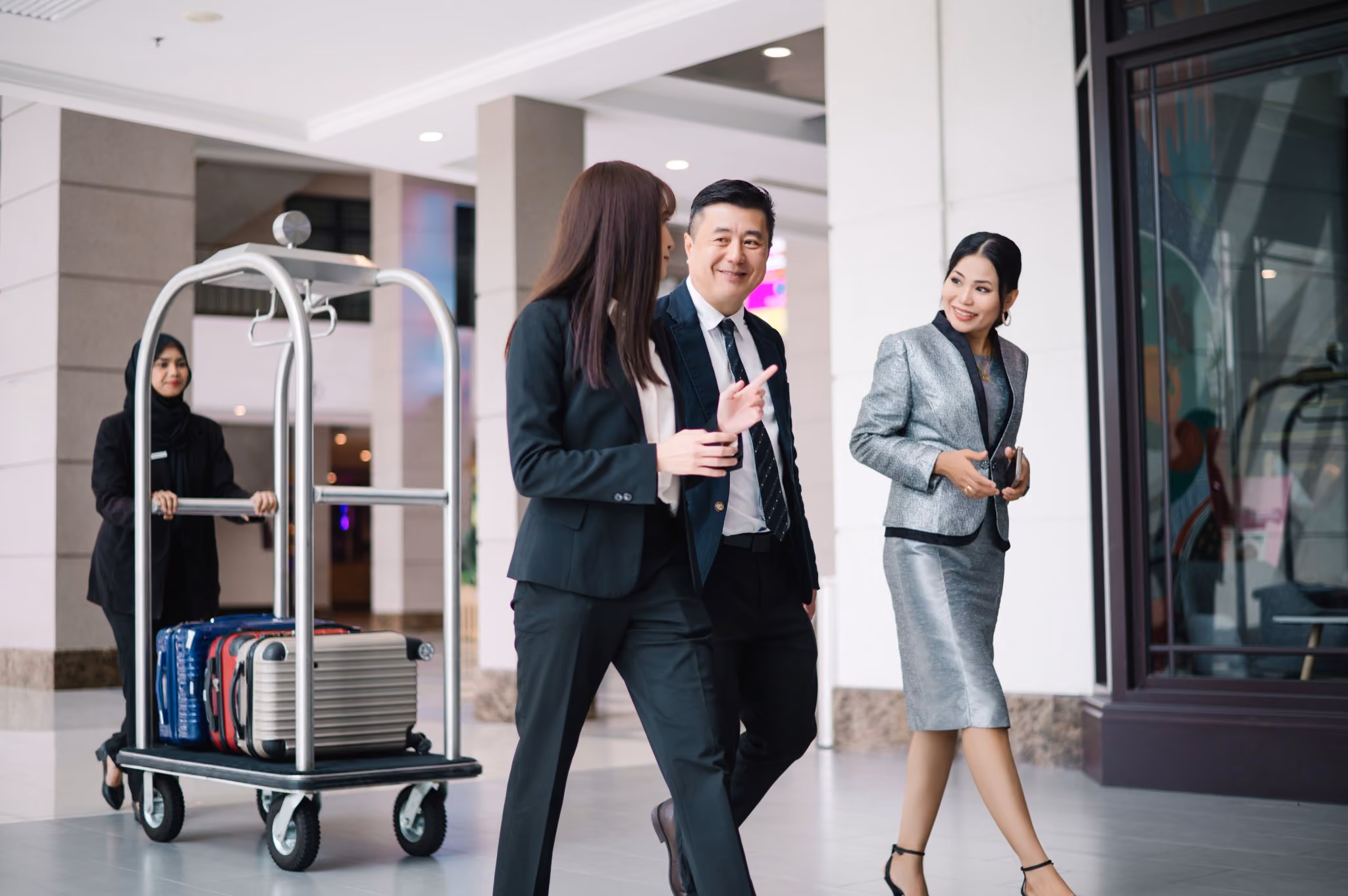 3 people walking and talking in a hotel