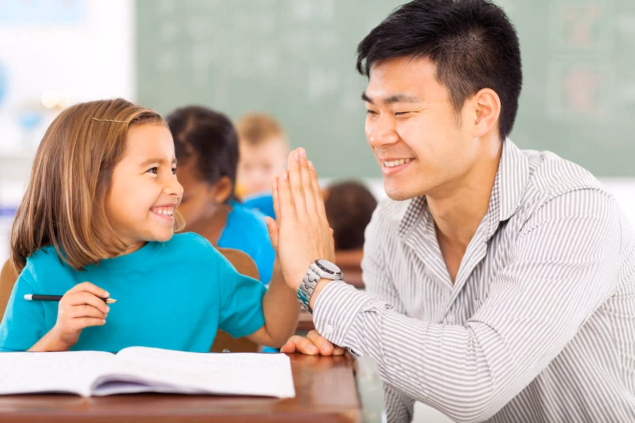 A teacher and a student high fiving