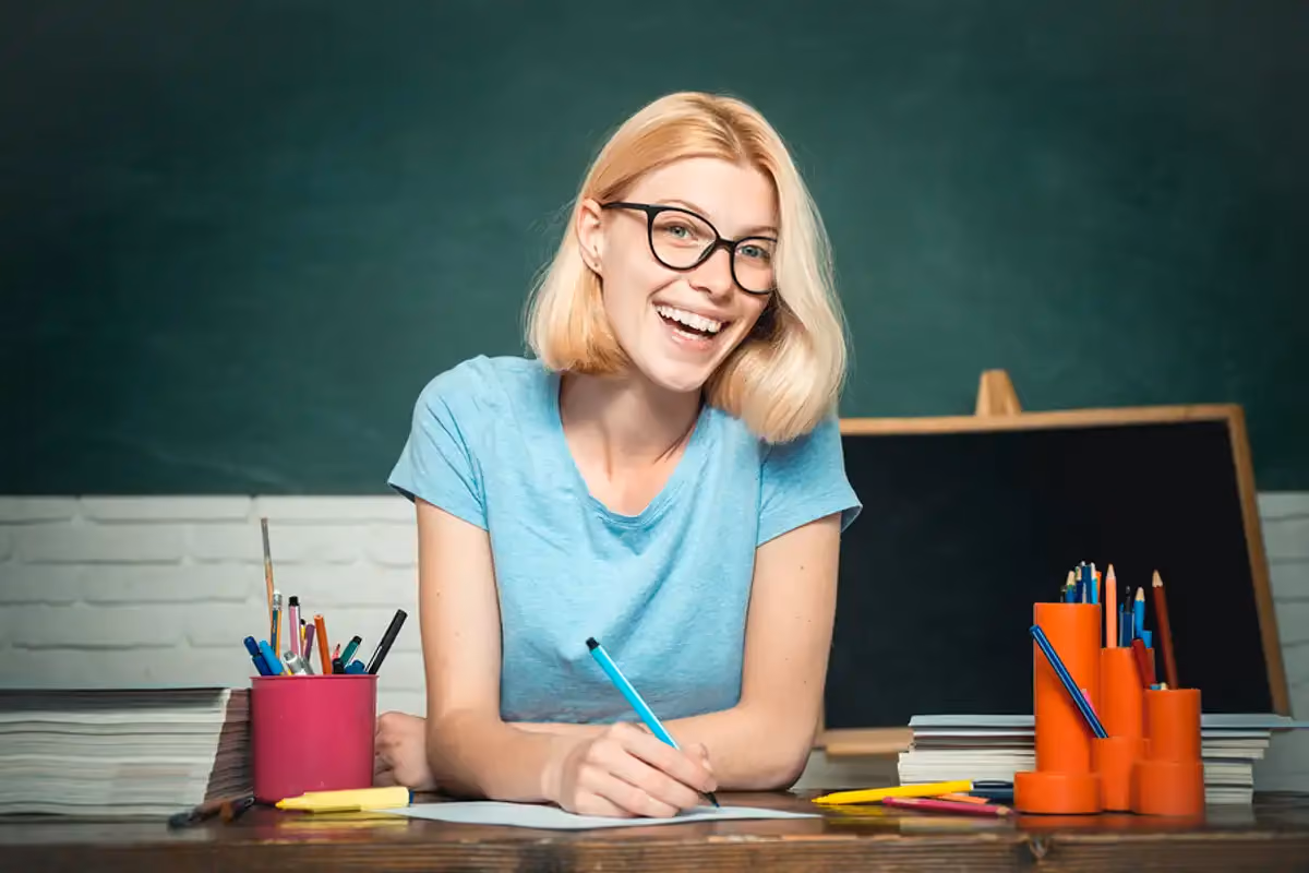 A happy young teacher grades an assignment from one of her students