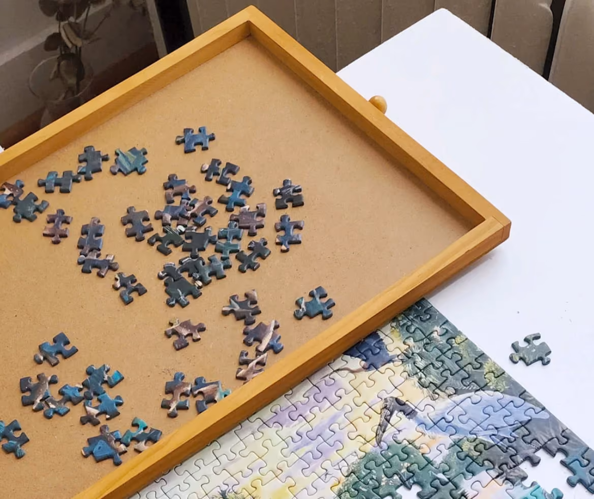 A wooden tray holding a single puzzle piece, showcasing its smooth surface and natural grain.