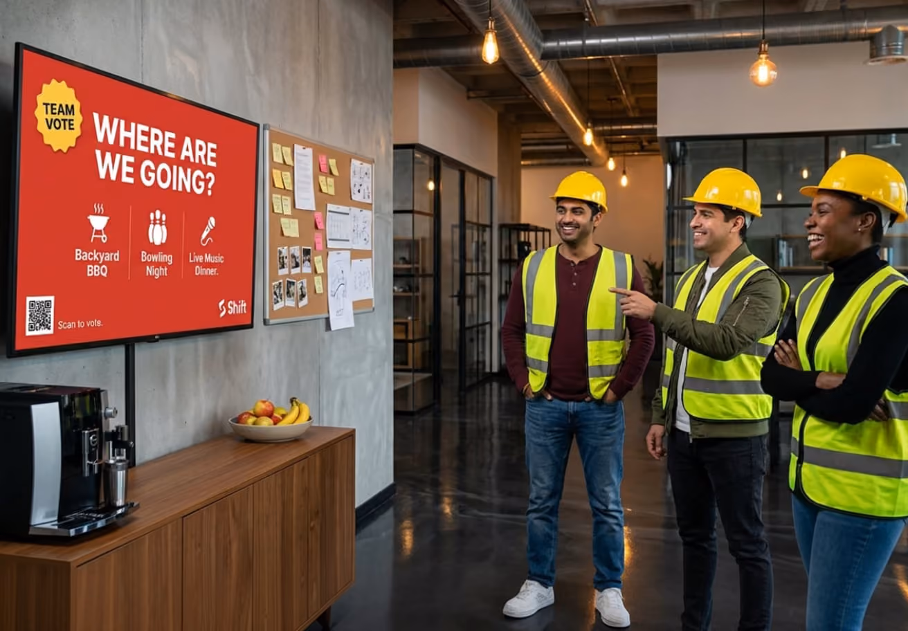 A group of individuals in safety vests stands in front of a large screen displaying information.