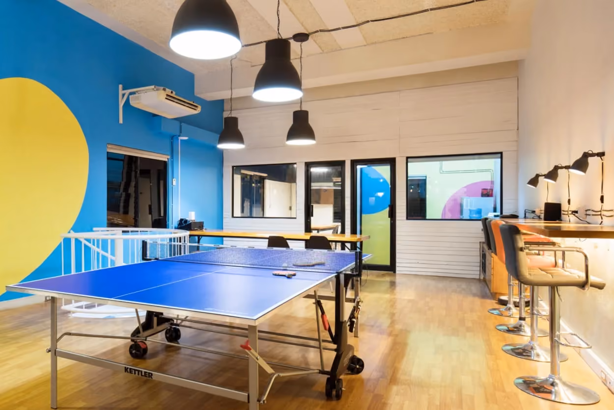 A ping pong table set in a room with vibrant yellow and blue walls, creating a lively atmosphere for play.