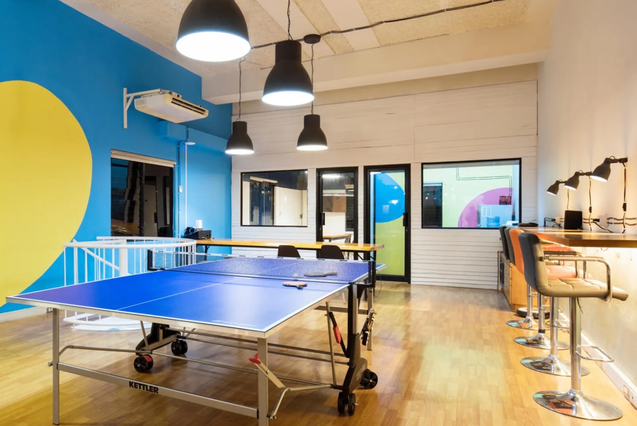 A ping pong table set in a room with vibrant yellow and blue walls, creating a lively atmosphere for play.