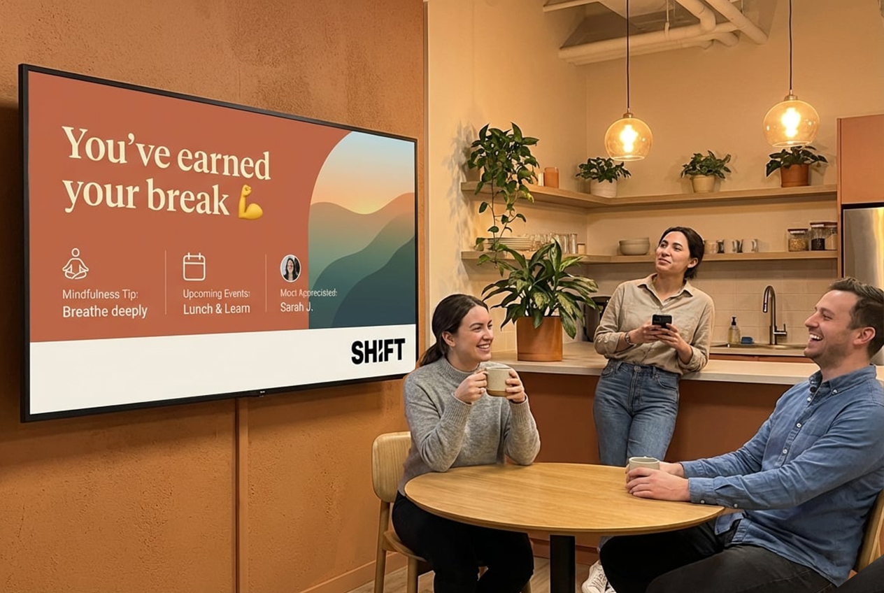 Three people seated at a table, watching a TV screen in a casual setting.
