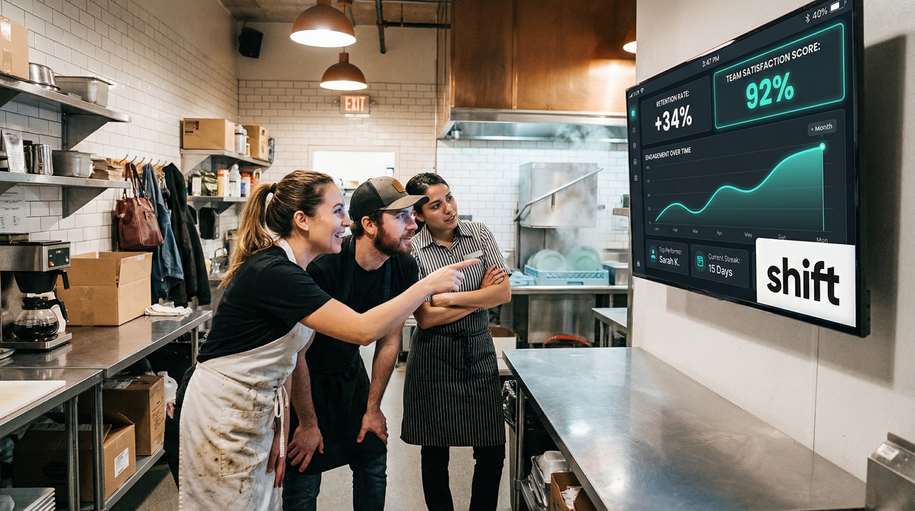 Three people in a kitchen observe a monitor displaying a chart, engaged in discussion about the data presented. 