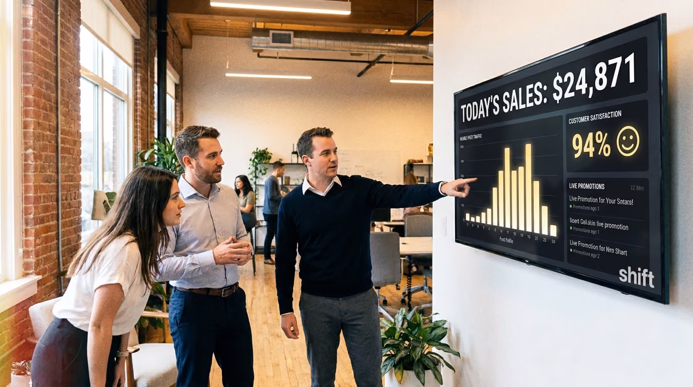 Three individuals observe a large screen displaying a detailed graph during a presentation. 