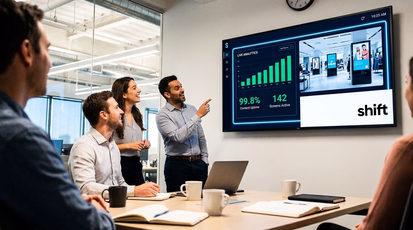 A group of people seated in a meeting room, attentively watching a presentation displayed on a large screen. 