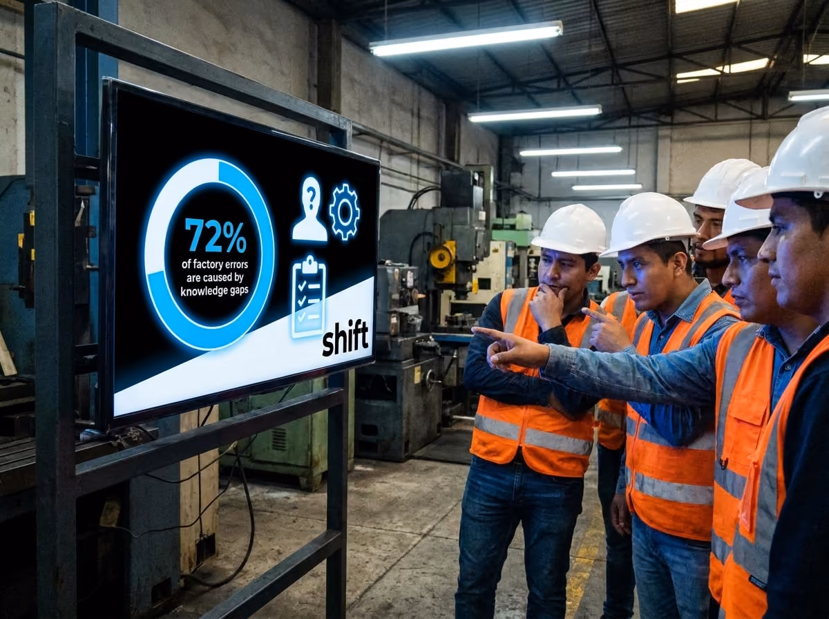 A team of men in hard hats is gathered around a large screen, engaged in discussion about displayed information.  