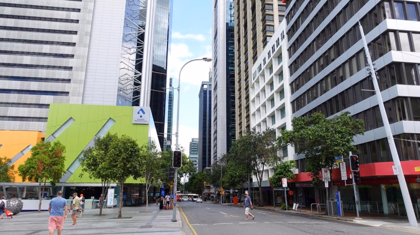 A busy street lined with tall buildings, featuring people walking and engaging in various activities.
