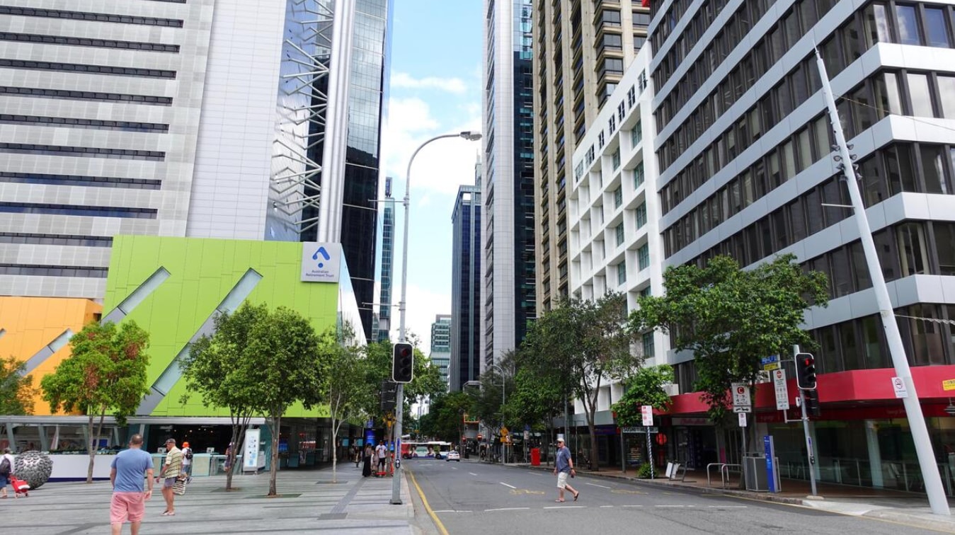 A busy street lined with tall buildings, featuring people walking and engaging in various activities.