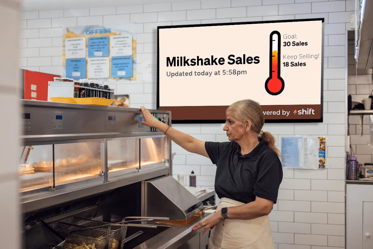 A woman stands in front of a milkshake machine, preparing to make a delicious milkshake.