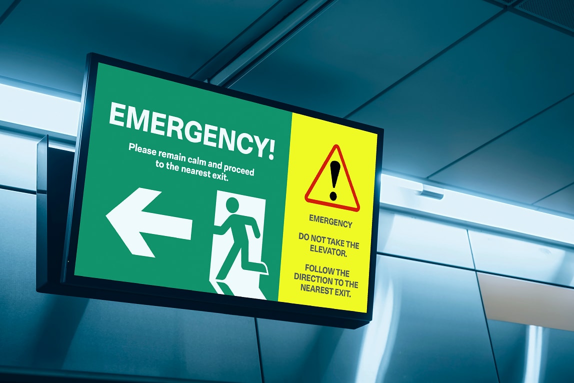 Emergency exit sign with arrow and warning: "Do not take the elevator. Follow the direction to the nearest exit.