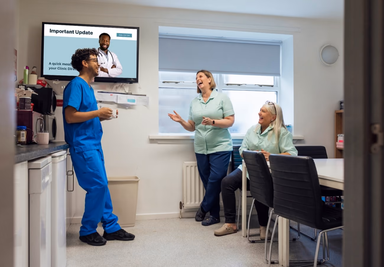 A group of diverse individuals gathered in a room, watching a television screen together.