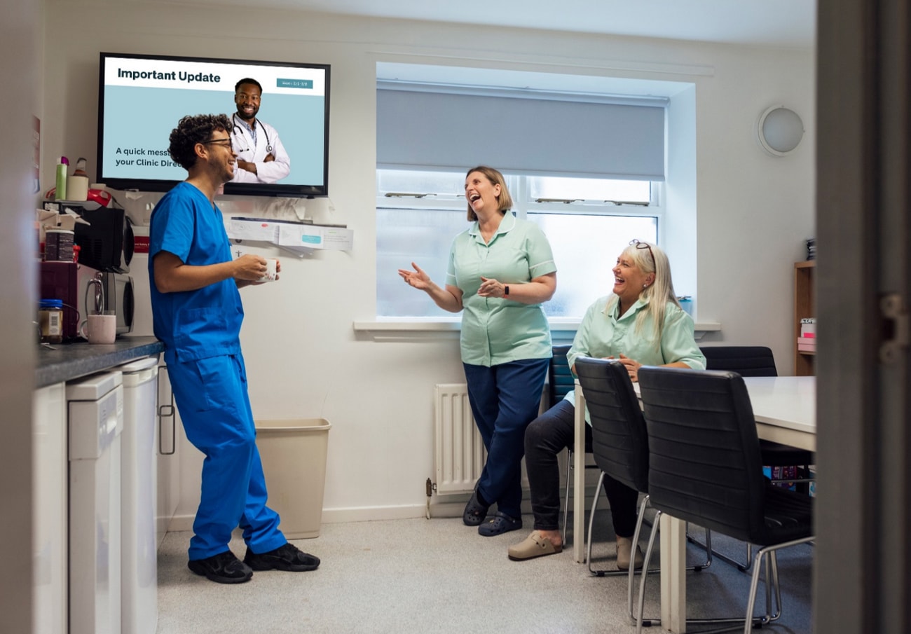 A group of diverse individuals gathered in a room, watching a television screen together.