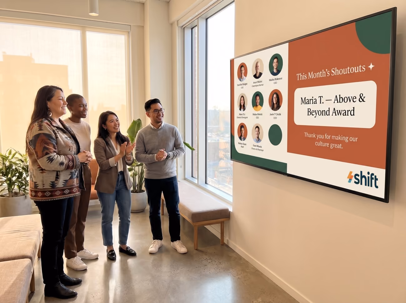 A group of four stands in front of a large screen with a graph, actively reviewing and discussing the information shown.