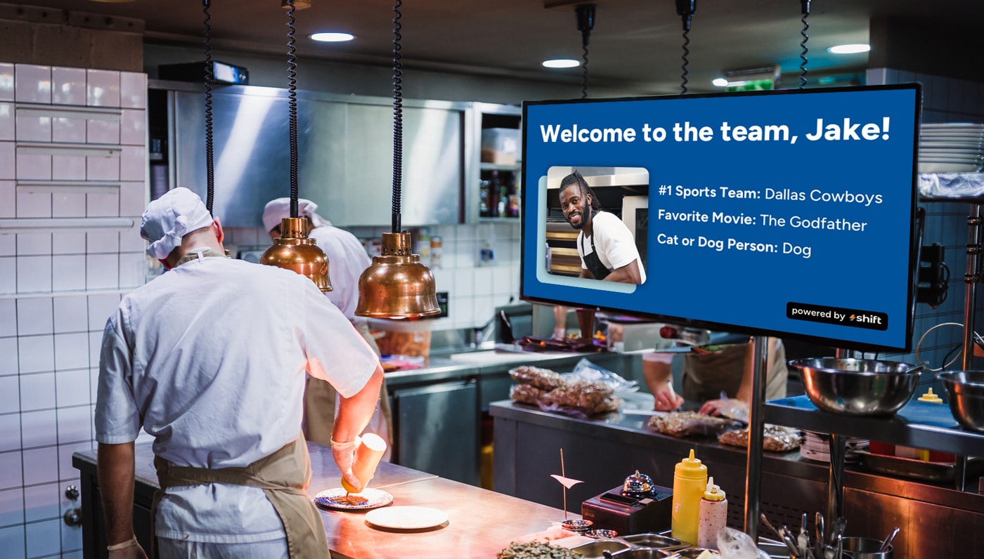 A chef stands in front of a large screen, presenting culinary techniques to an audience.