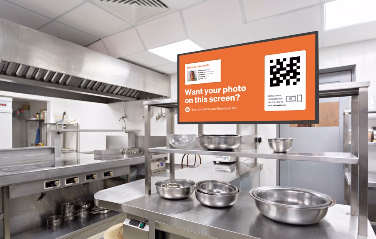 A modern kitchen featuring a large screen displaying a QR code for easy access to recipes or cooking instructions. 