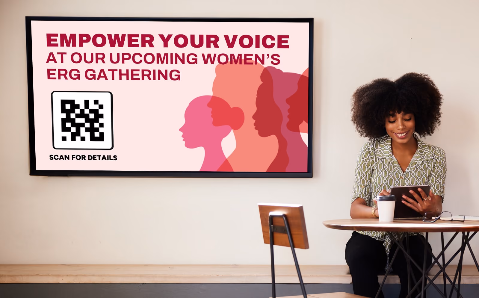 A woman seated in front of a digital sign