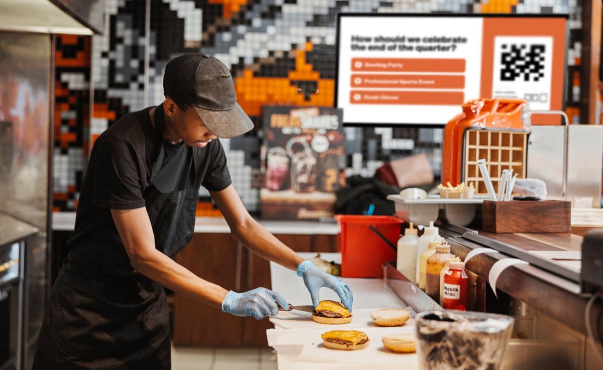 A man prepares food in a restaurant kitchen, focused on his cooking tasks with various ingredients around him.