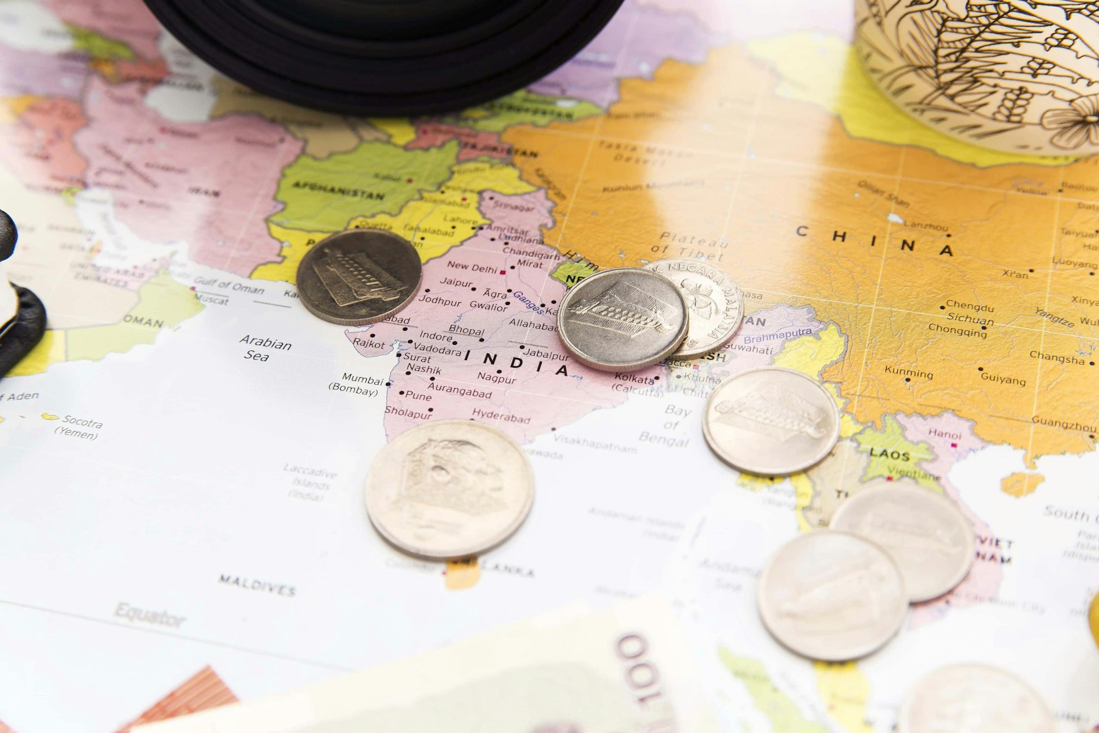 Coins spread across a world map, representing cross-border payments to international contractors
