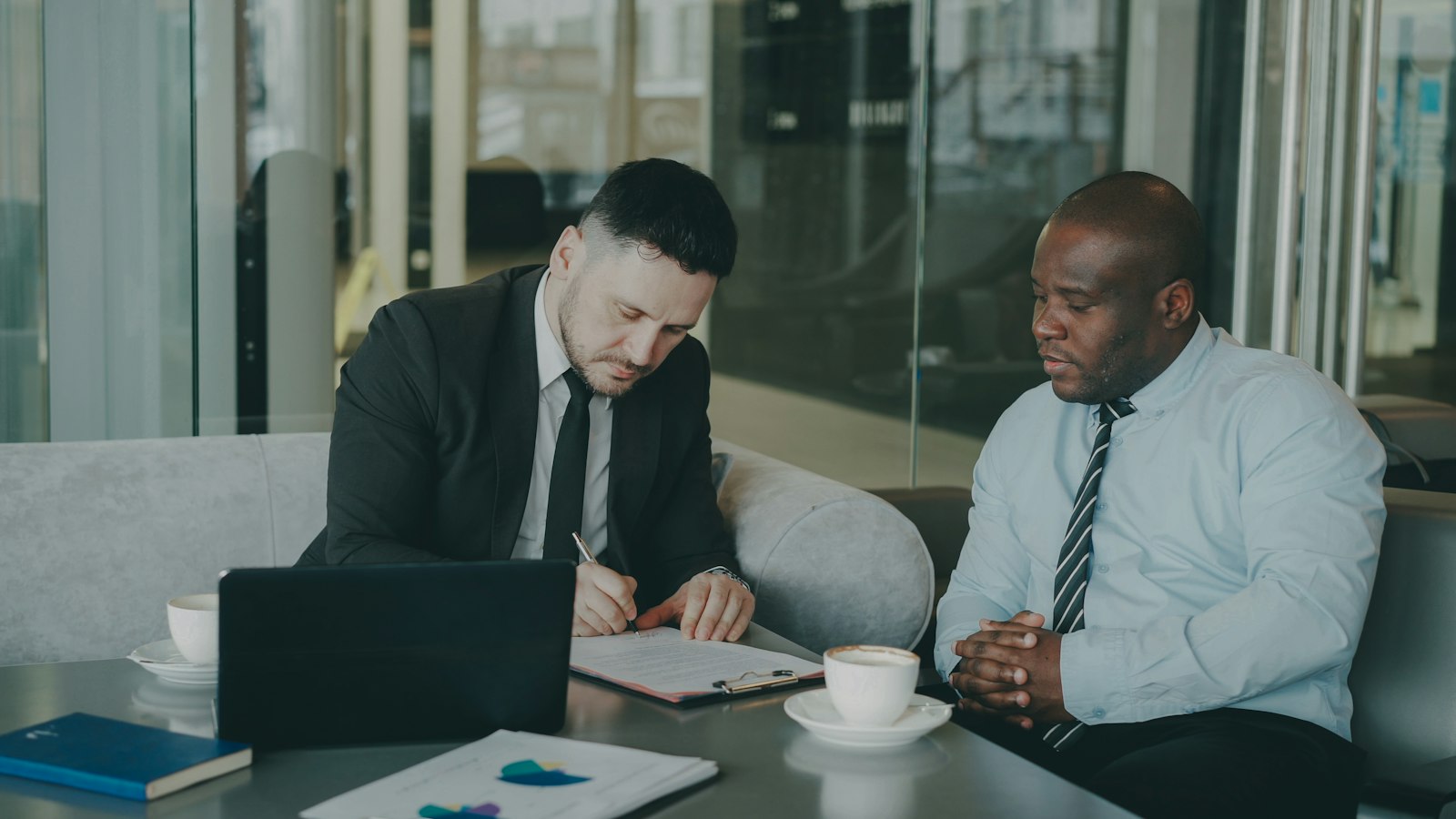Two businessmen signing a staffing contract at a conference table