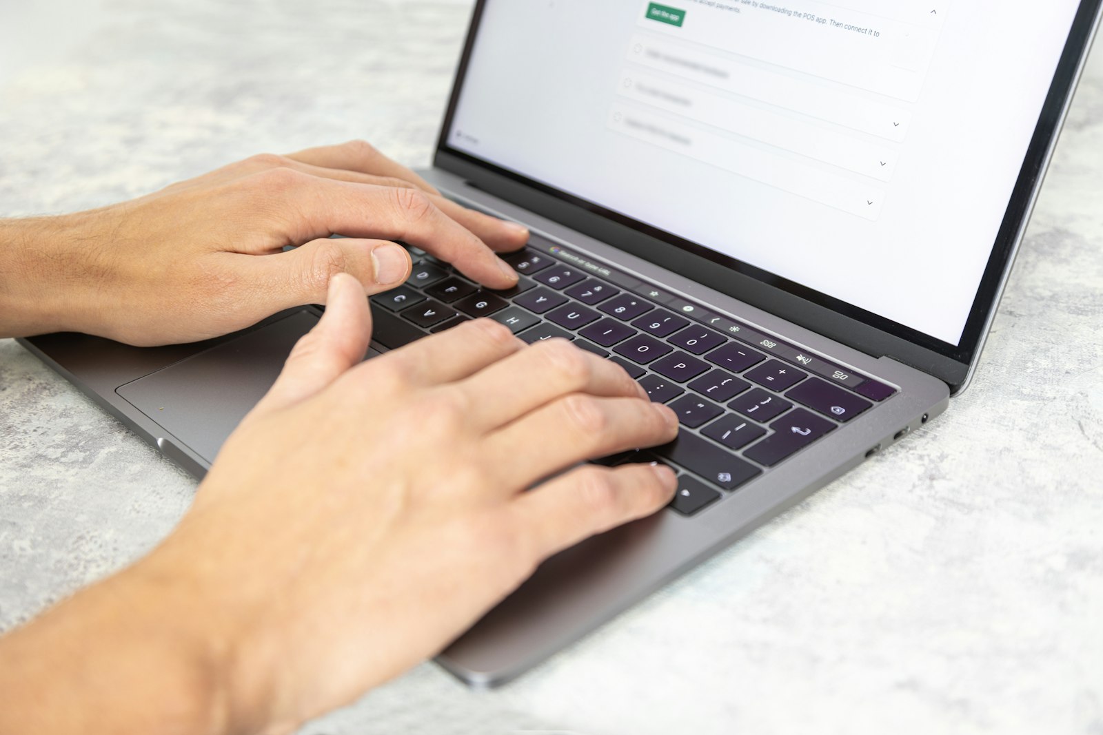 Copywriter typing on a laptop while drafting marketing copy