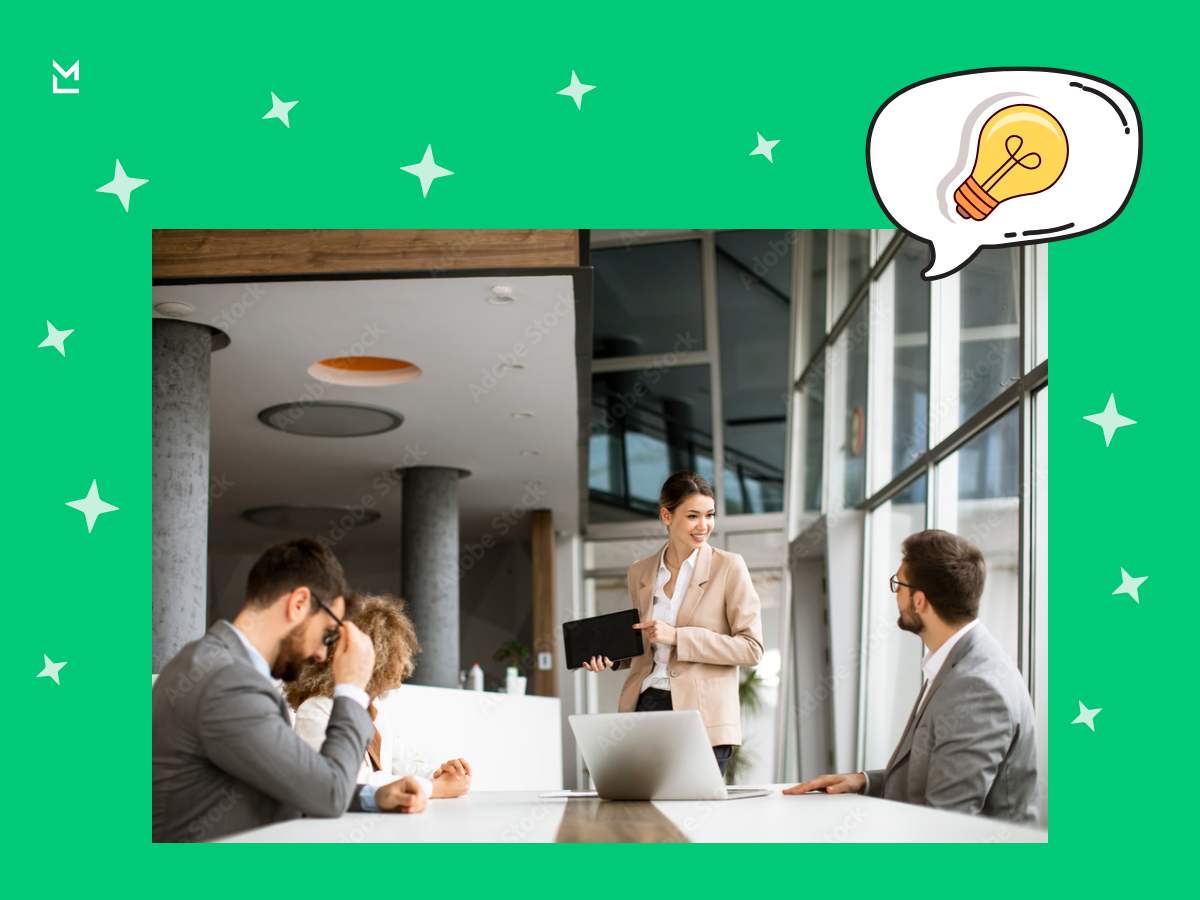 Business team brainstorming in modern office - collaborative meeting with laptops and tablet, discussing creative ideas and business strategy