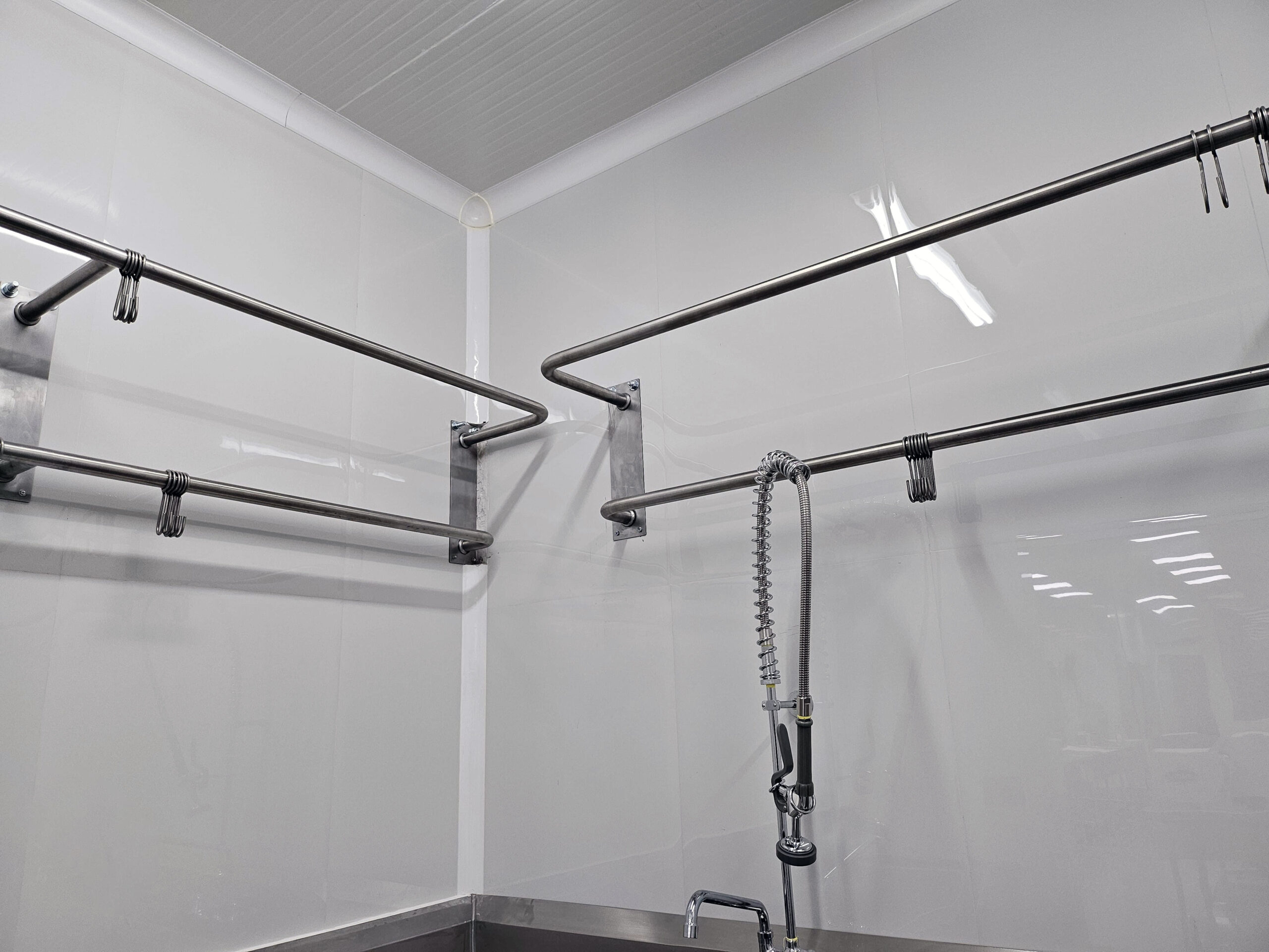 Preformed CoRound corner detail in a sanitary processing room with stainless hanging rails