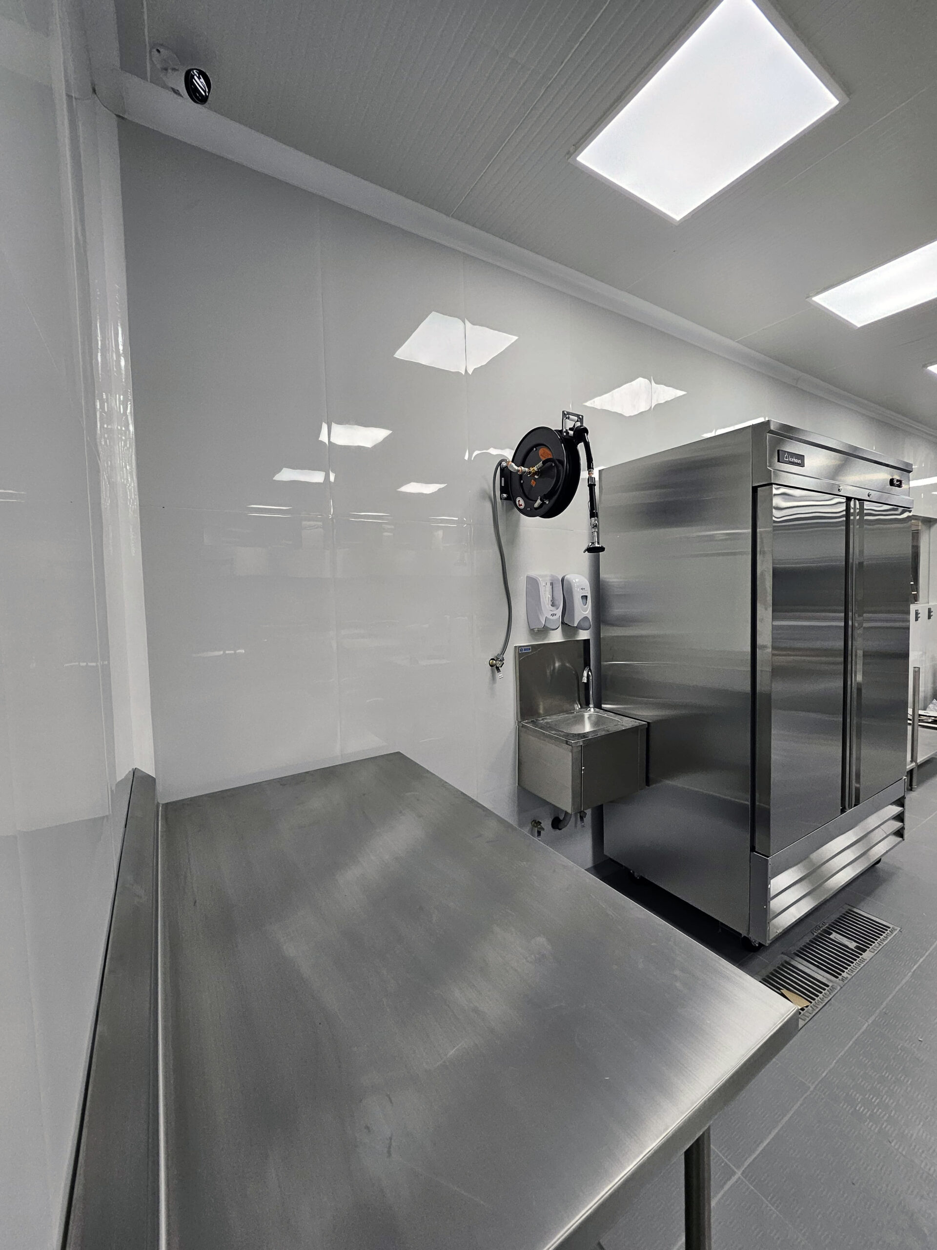 Sanitary room with flush white wall panels and CoRound hygienic PVC coving