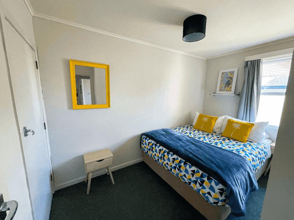 Queen bedroom at The Ascot Flat 1, a 2-bedroom holiday flat in Gisborne. Part of Accommodation in Gisborne, featuring a cosy bed setup with natural light and modern decor.
