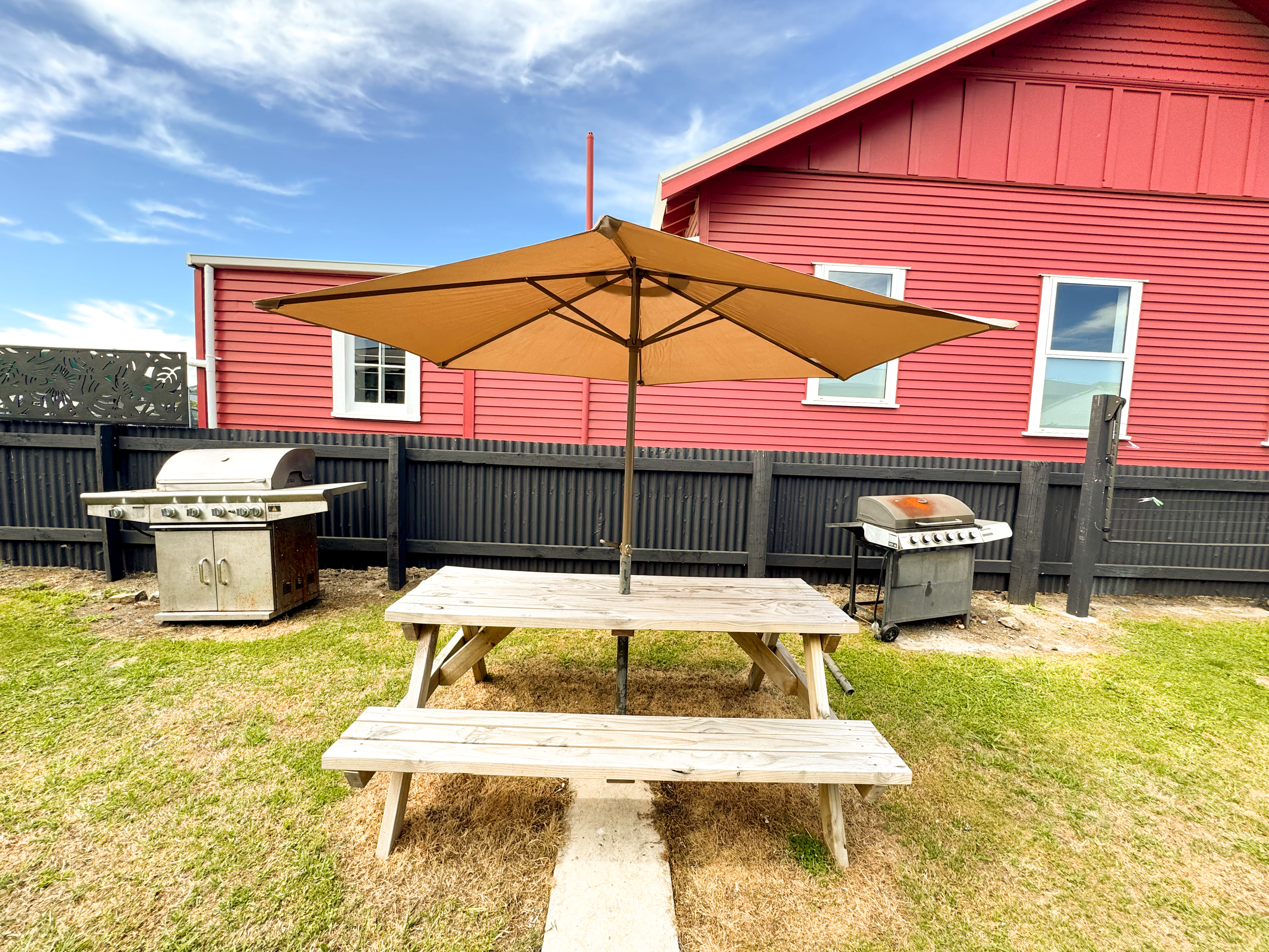 Shared outdoor area at 325 Childers Road, Gisborne, featuring picnic table and BBQ facilities for guests