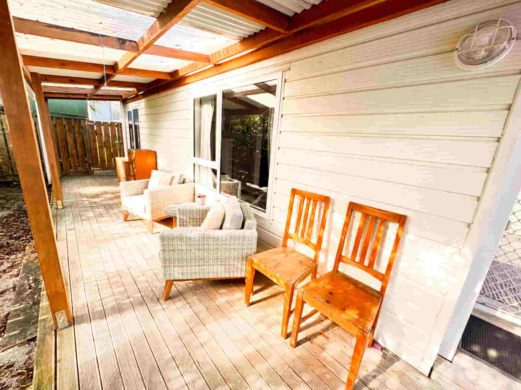 Outdoor deck at Railway Nook, 2-bedroom accommodation in Gisborne — photo shows a table, chairs