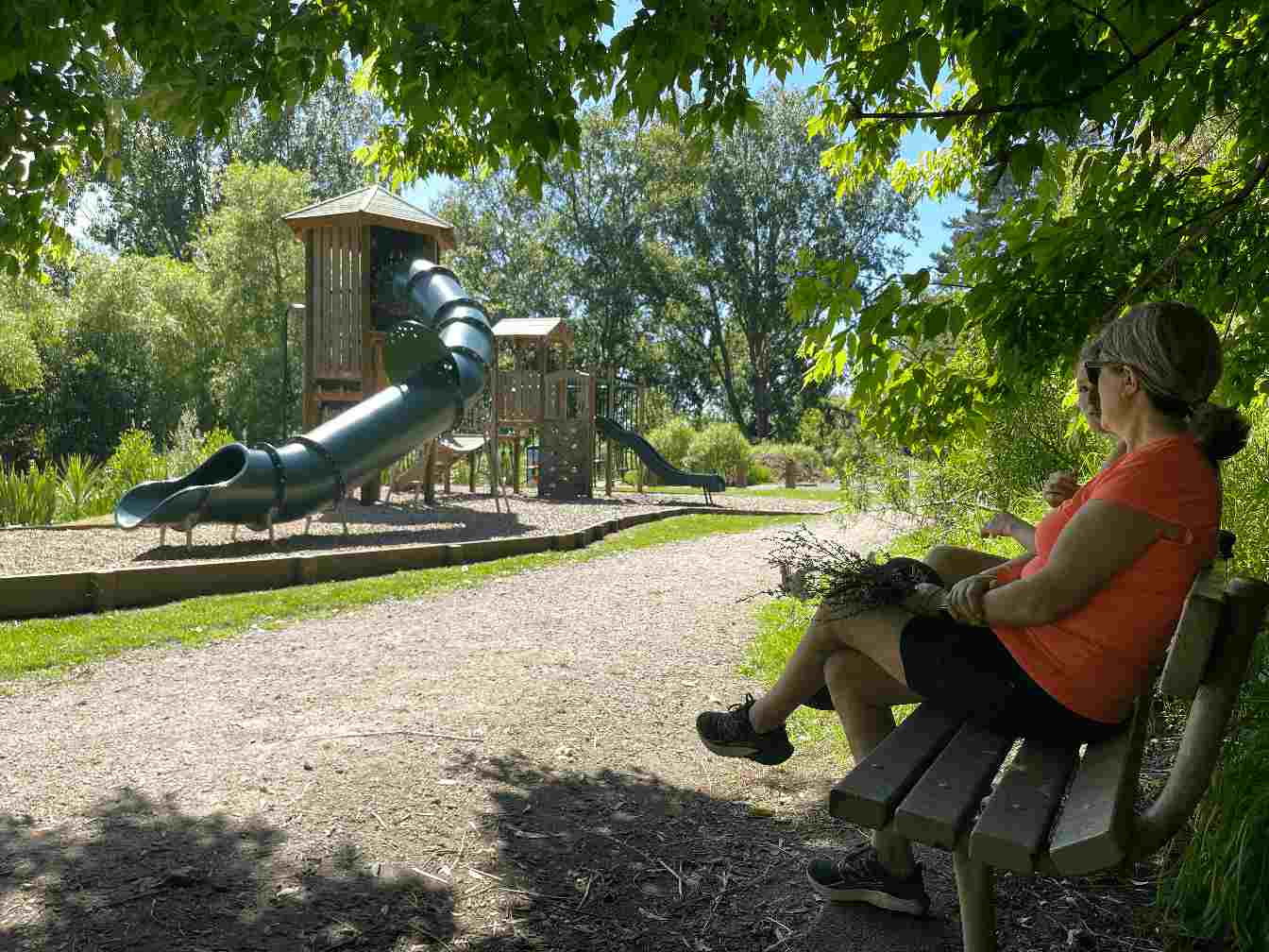 photo is of kaiti hill playground showing two mums sitting and watching childern play on a sunny day in Gisborne New Zealand