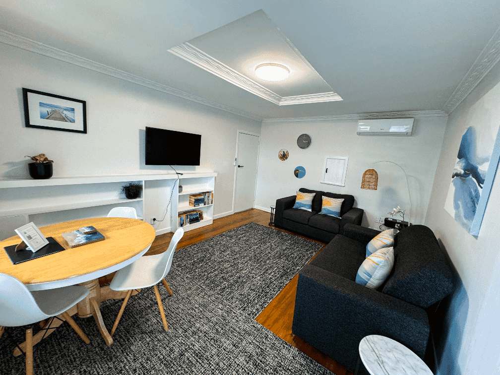Ascot Apartments flat 2 325 photo of lounge room, dinning table, blue sofa bed couch, blue couch, black leather couch, tv, aircon heat pump, wooden floors