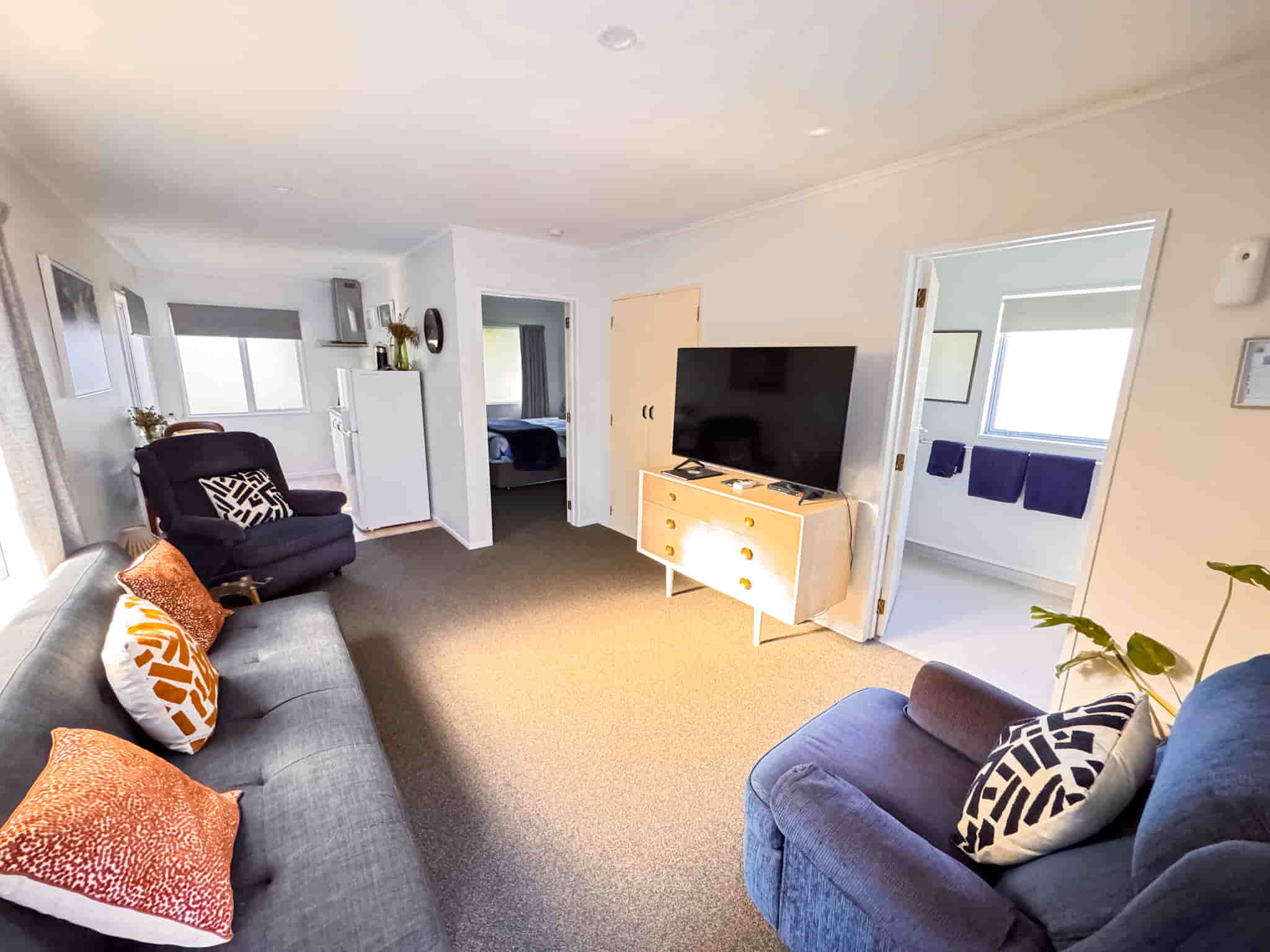 Front of The Railway Nook, a cozy 1-bedroom standalone cottage in Gisborne with a fenced yard, private driveway, and outdoor seating area.