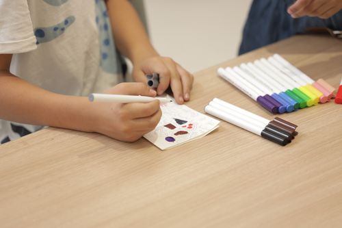 Close up of a student drawing with markers