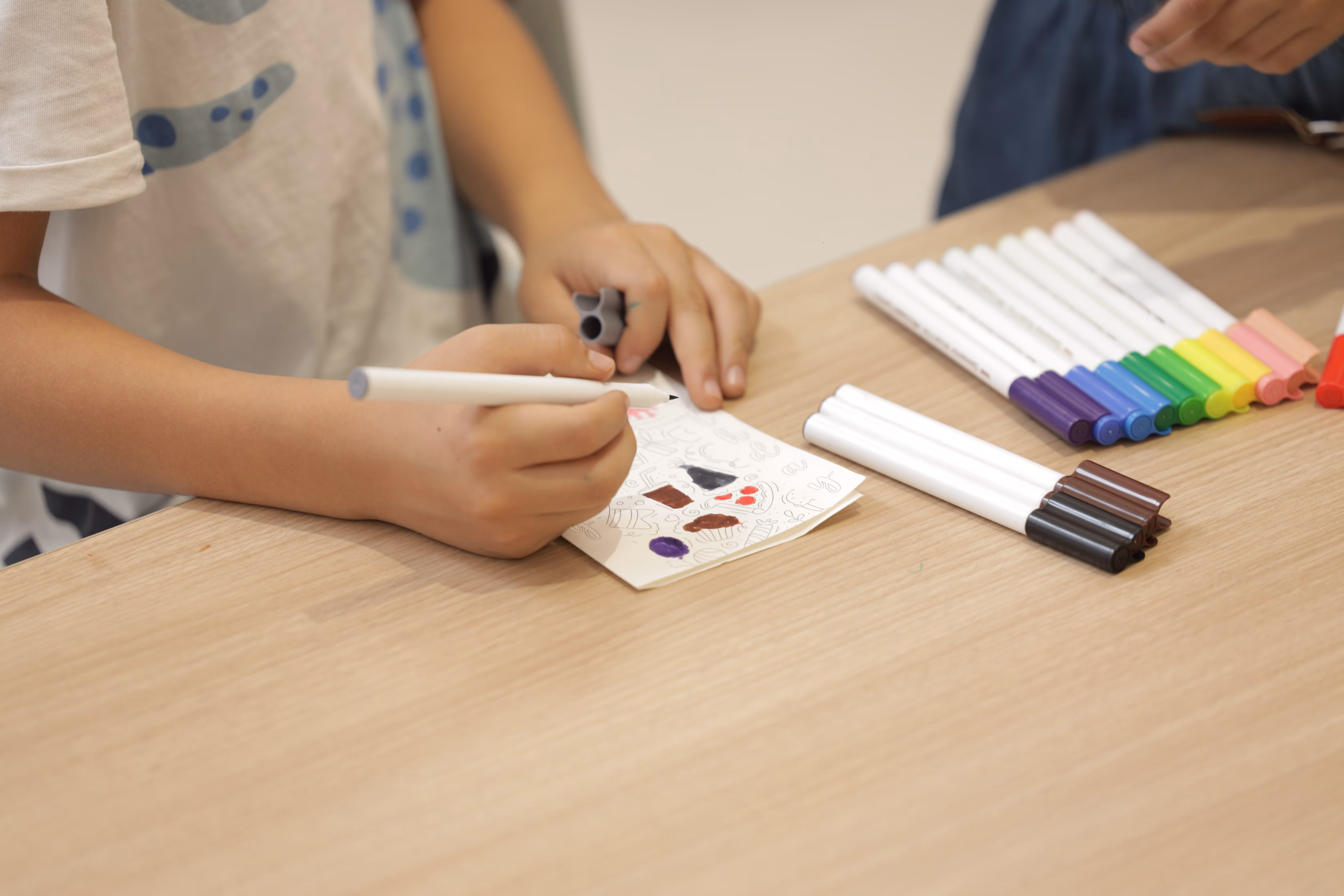 Close up of a student drawing with markers