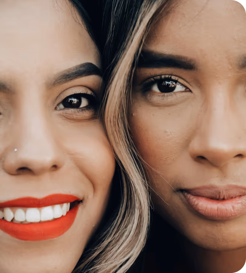 Close-up of two women side by side, one smiling with red lipstick, the other with neutral lips.