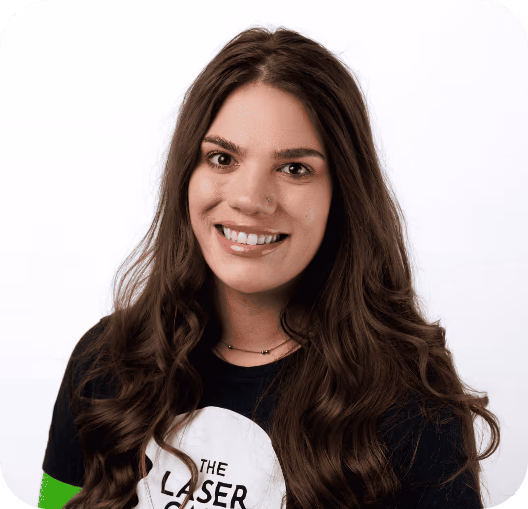 Smiling woman with long brown hair wearing a black t-shirt with a 'The Laser Cafe' logo.