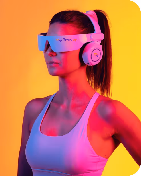 Woman wearing a white sports bra and futuristic BrainTap headset against a yellow background with pink lighting.