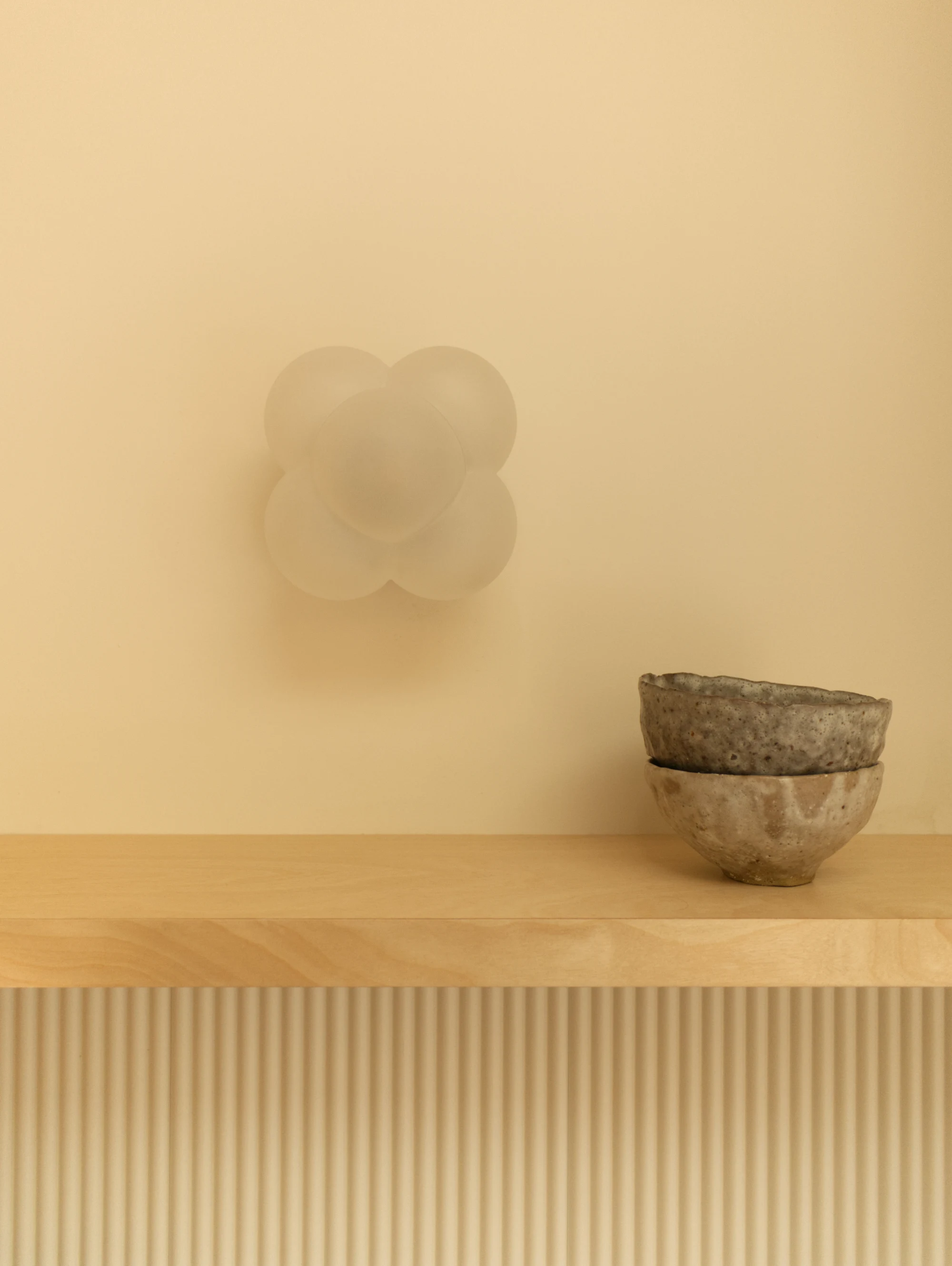 Détail d'un luminaire de design français et de bols en grès artisanaux, partis pris de l'architecte d'intérieur pour ce projet de rénovation de cuisine.